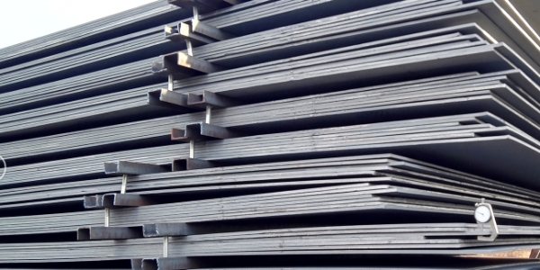 Piles of high quality steel plates are neatly placed.
